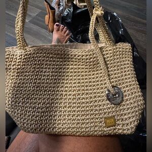 The Sak Woven Straw Tote in Natural Tan with Silver Charm